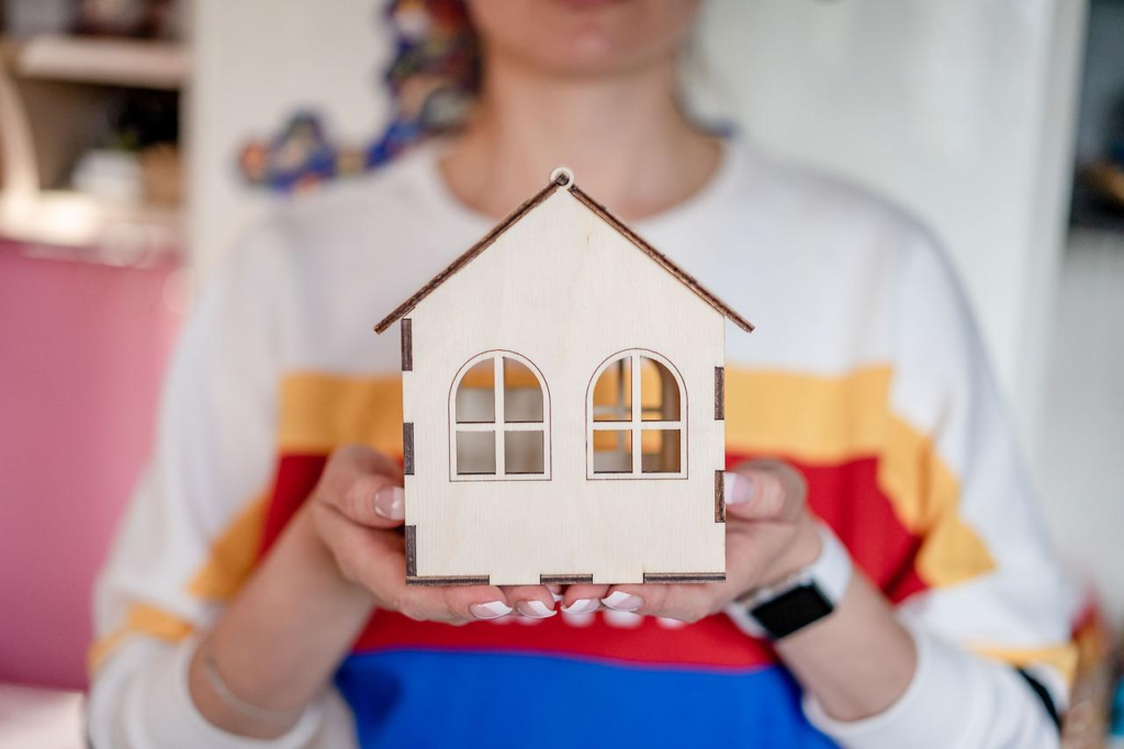 A Woman Holding a Model House 