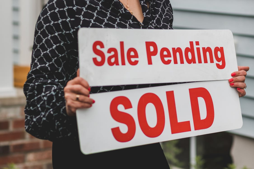 A real estate agent holding a “SOLD” sign