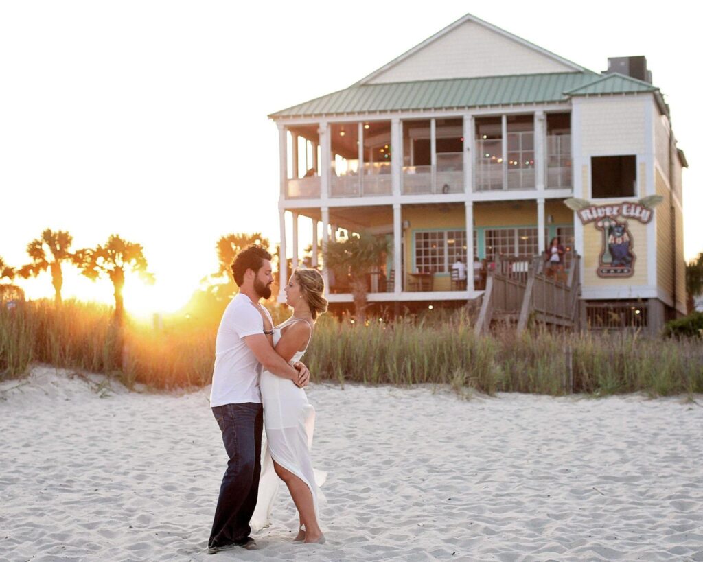 A couple embracing each other outside their beach house